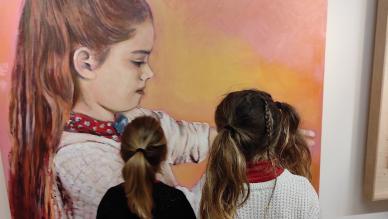 deux petites filles de dos devant une peinture de petite fille