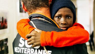 Enfant dans les bras de sauveteur SOS méditerranée