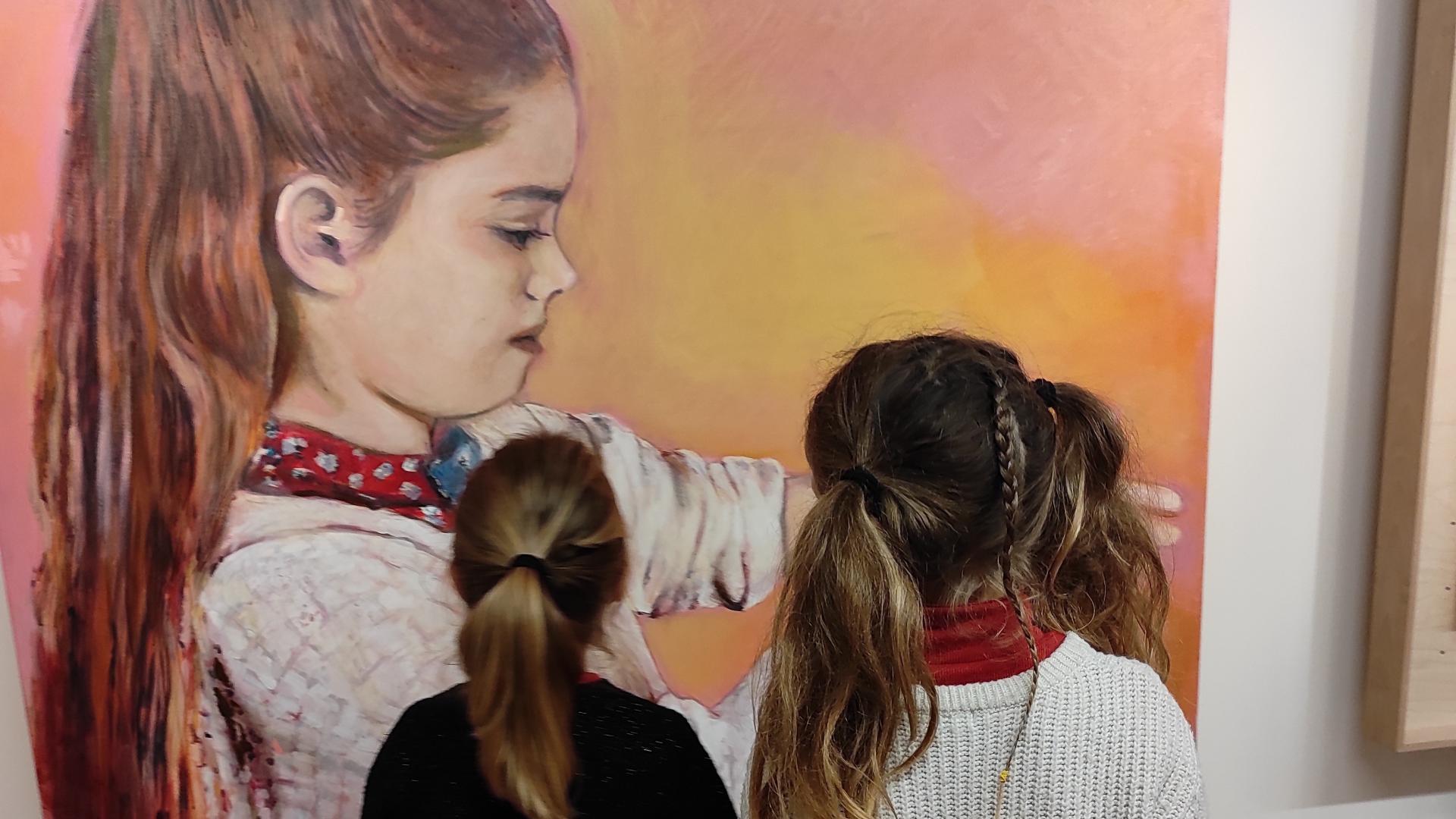 deux petites filles de dos devant une peinture de petite fille