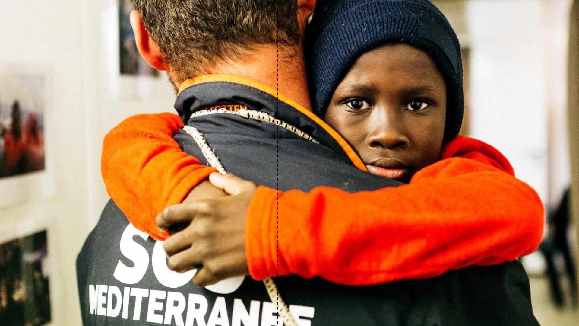 Enfant dans les bras de sauveteur SOS méditerranée
